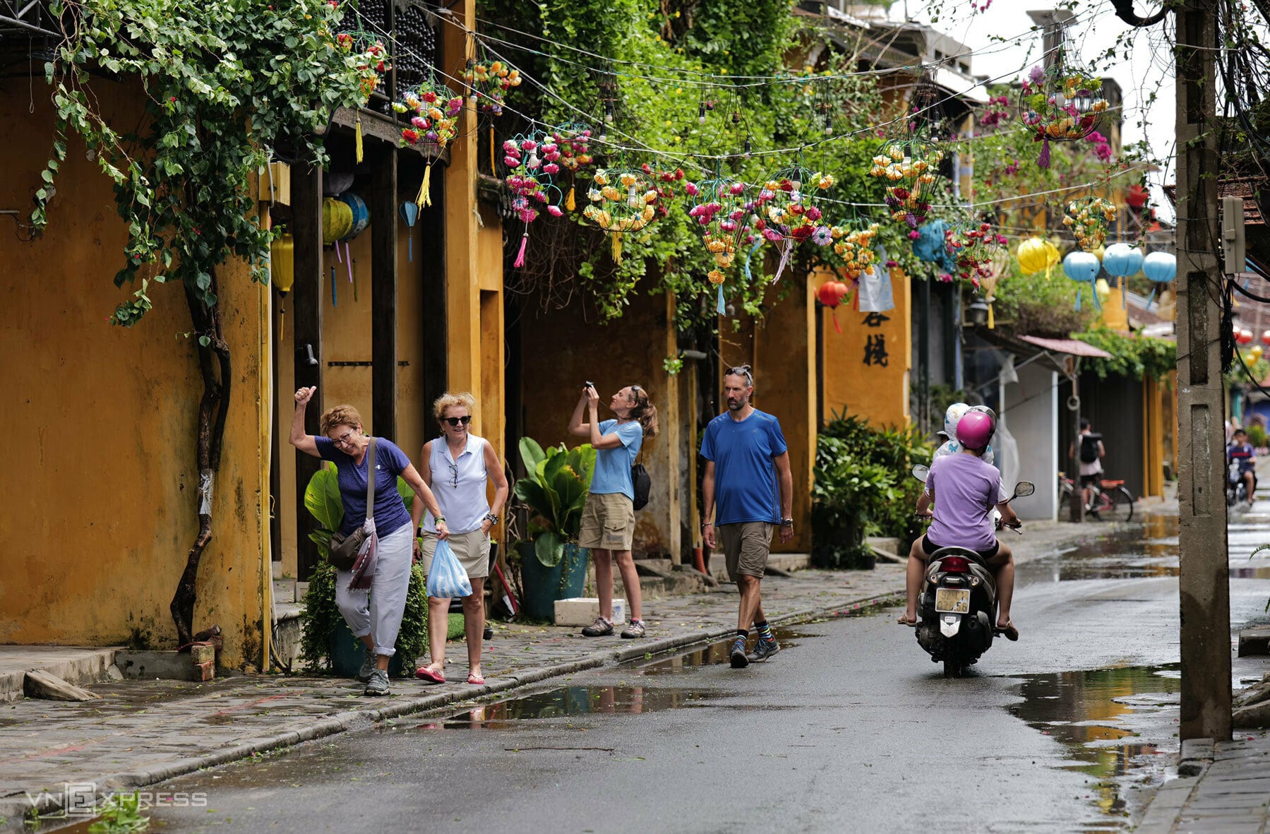 Foreign tourists walk on a street in Hoi An Town